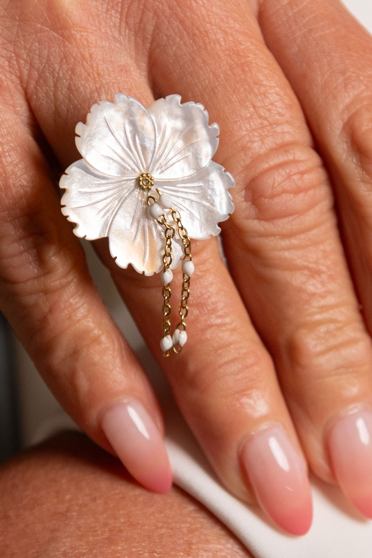Anello a fiore in madreperla indossato sulla mano